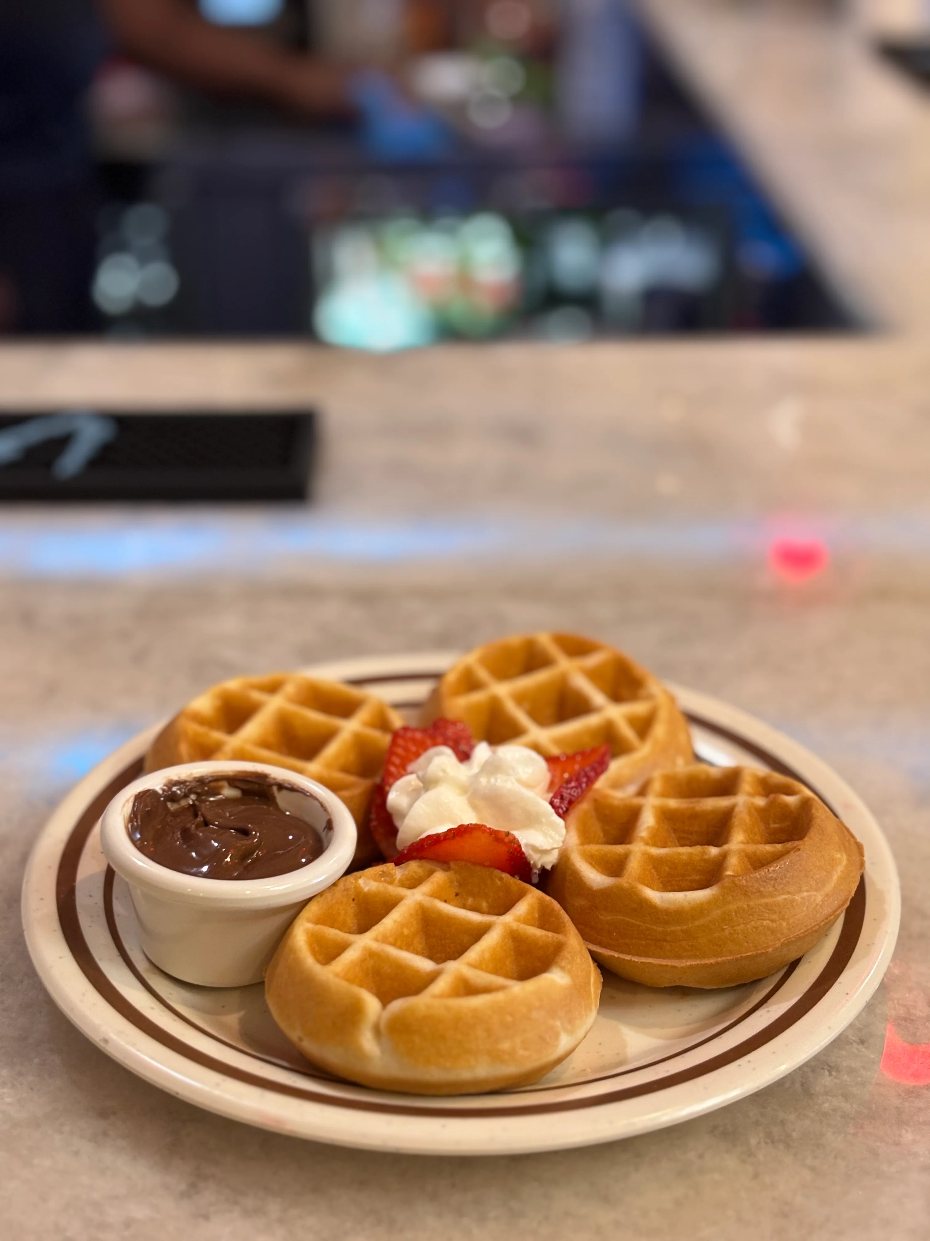 Belgian waffles served with chocolate sauce and strawberries