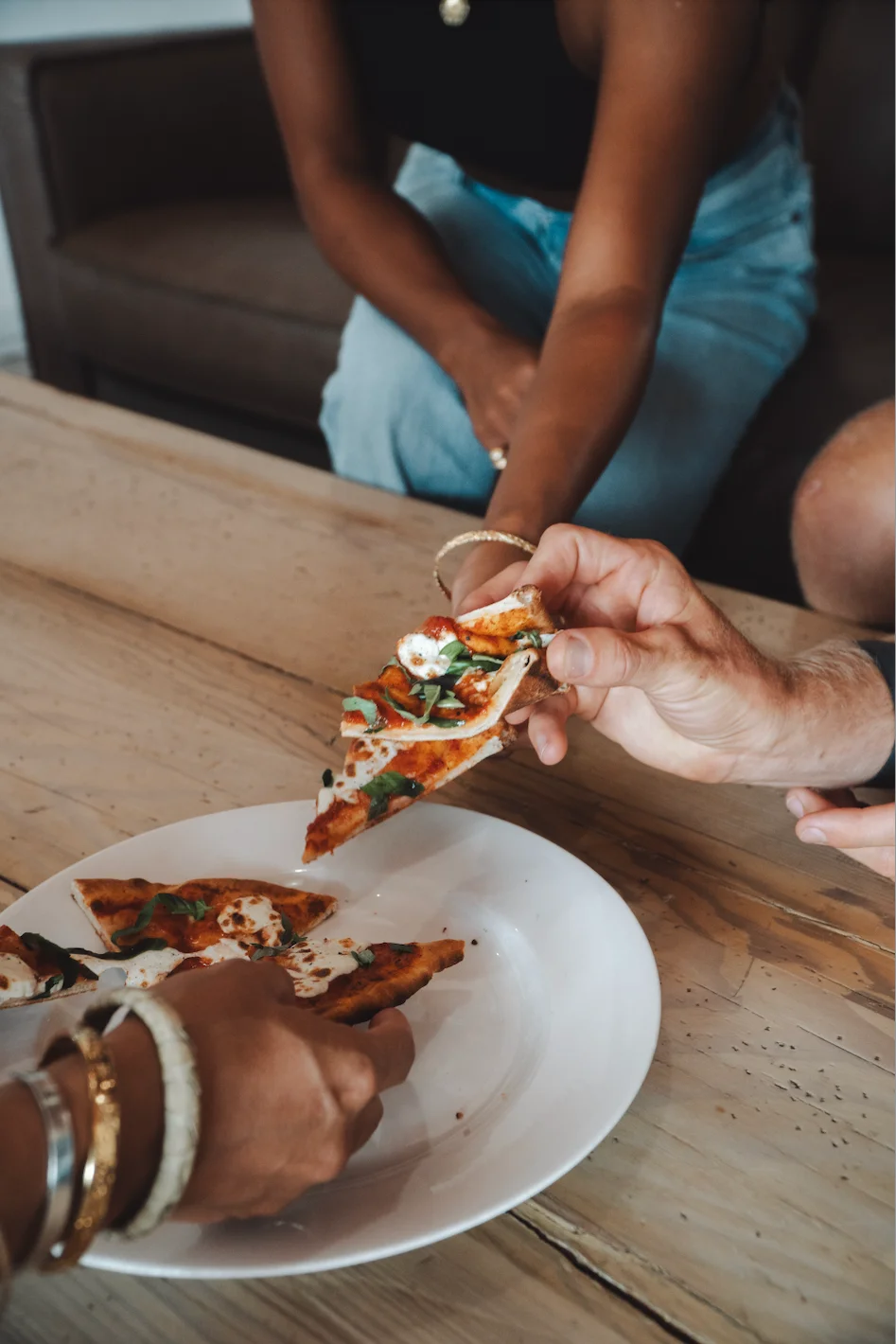 Sharing slices of Margherita pizza at a cozy restaurant