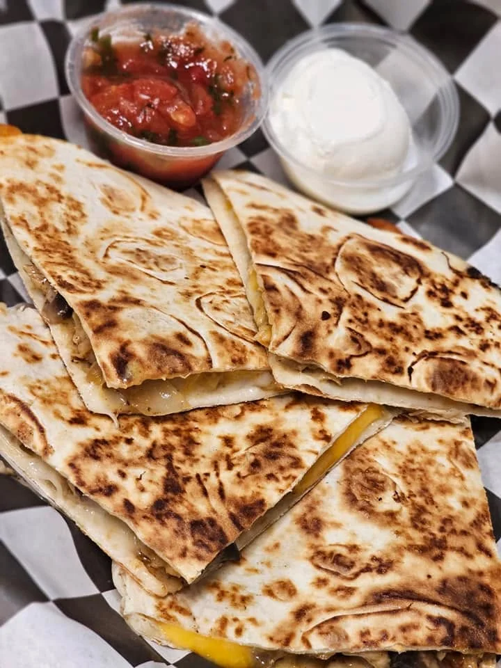 Delicious quesadilla served with salsa and sour cream