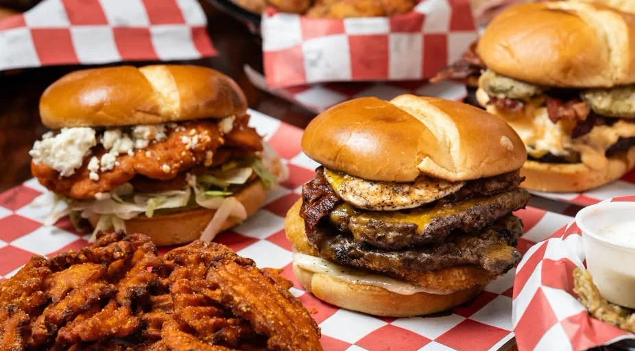 Gourmet burgers with crispy sides in a vibrant restaurant setting