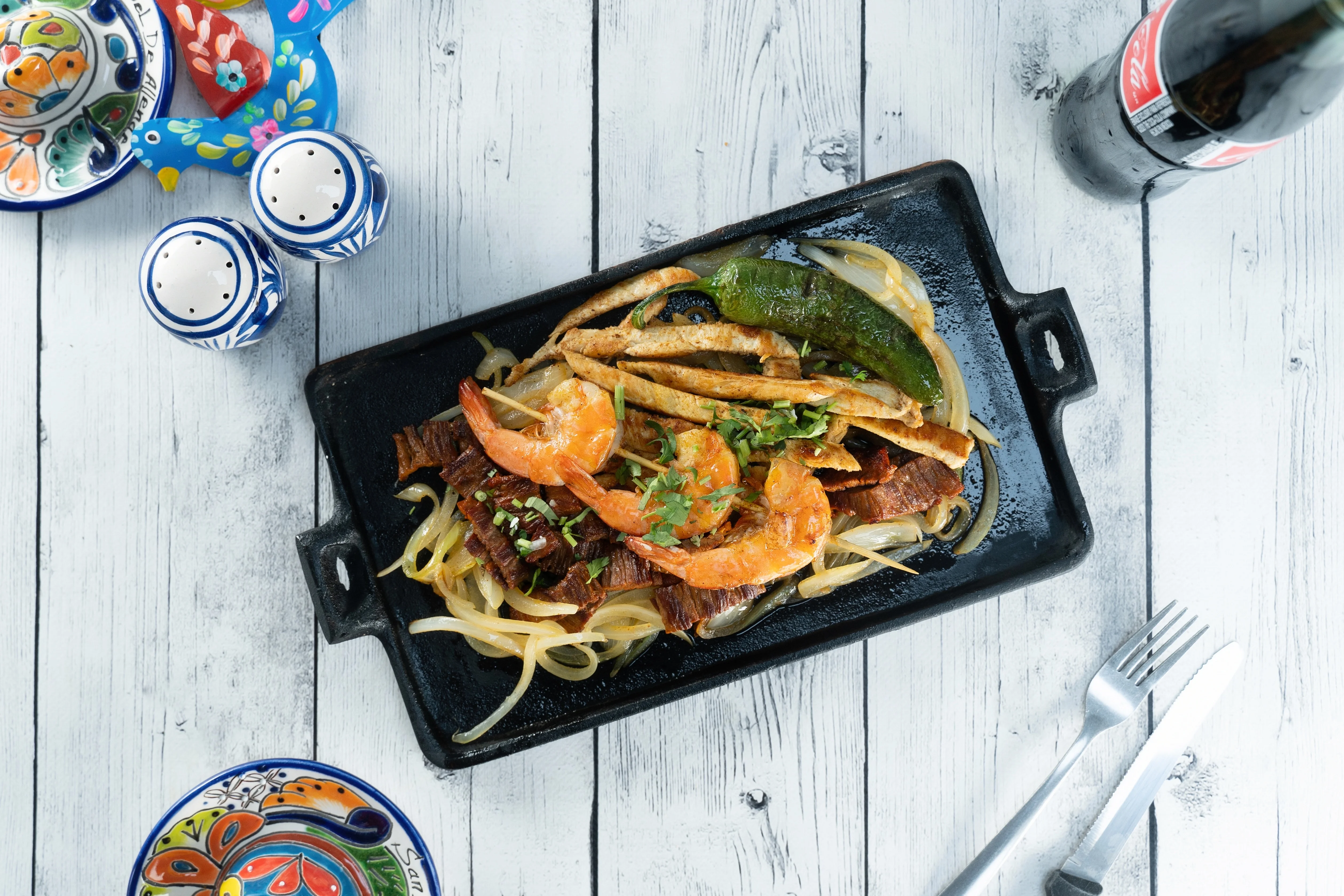Sizzling Mexican fajitas with shrimp and beef on a hot plate