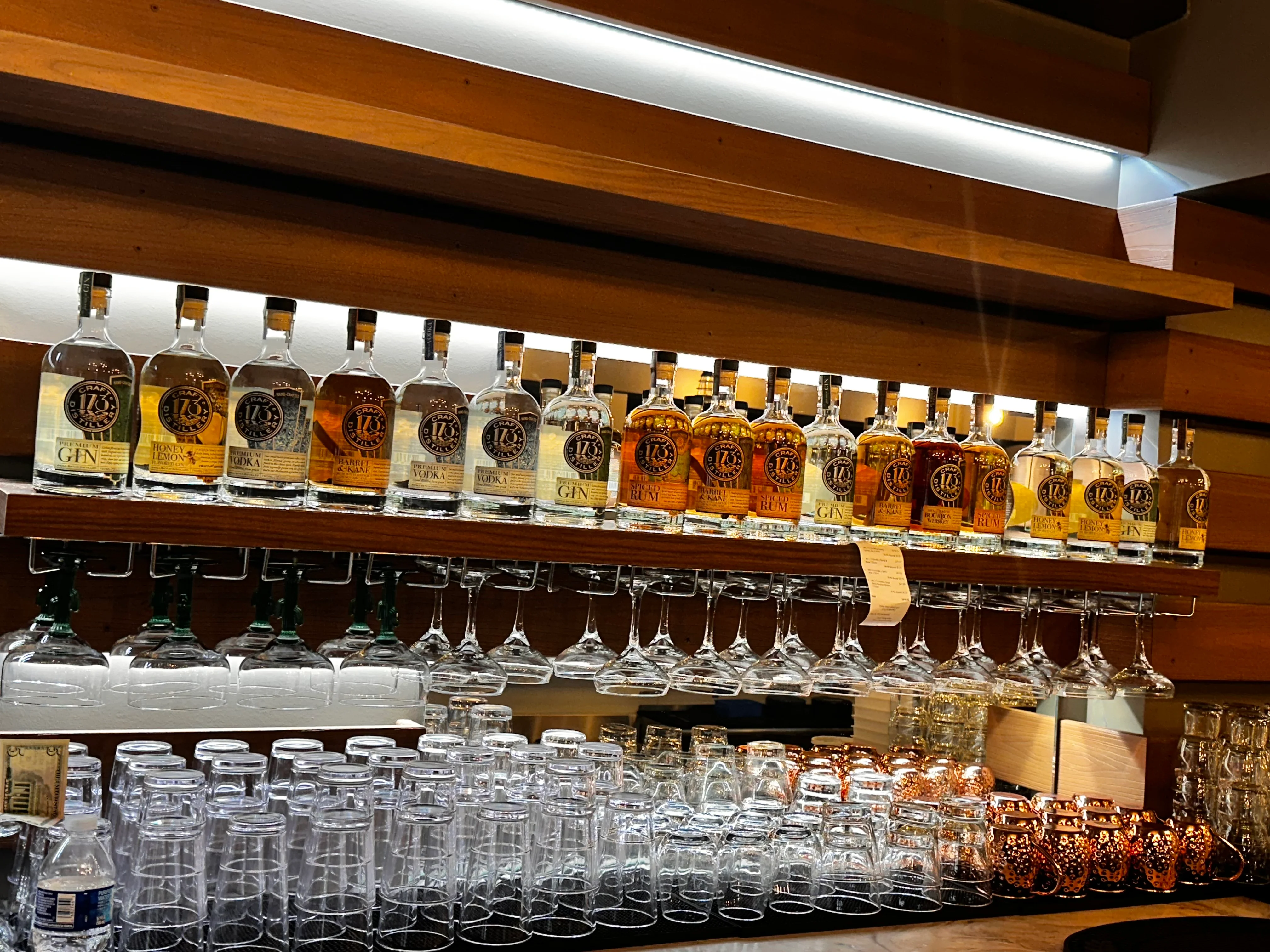 Variety of spirits displayed on a wooden bar shelf