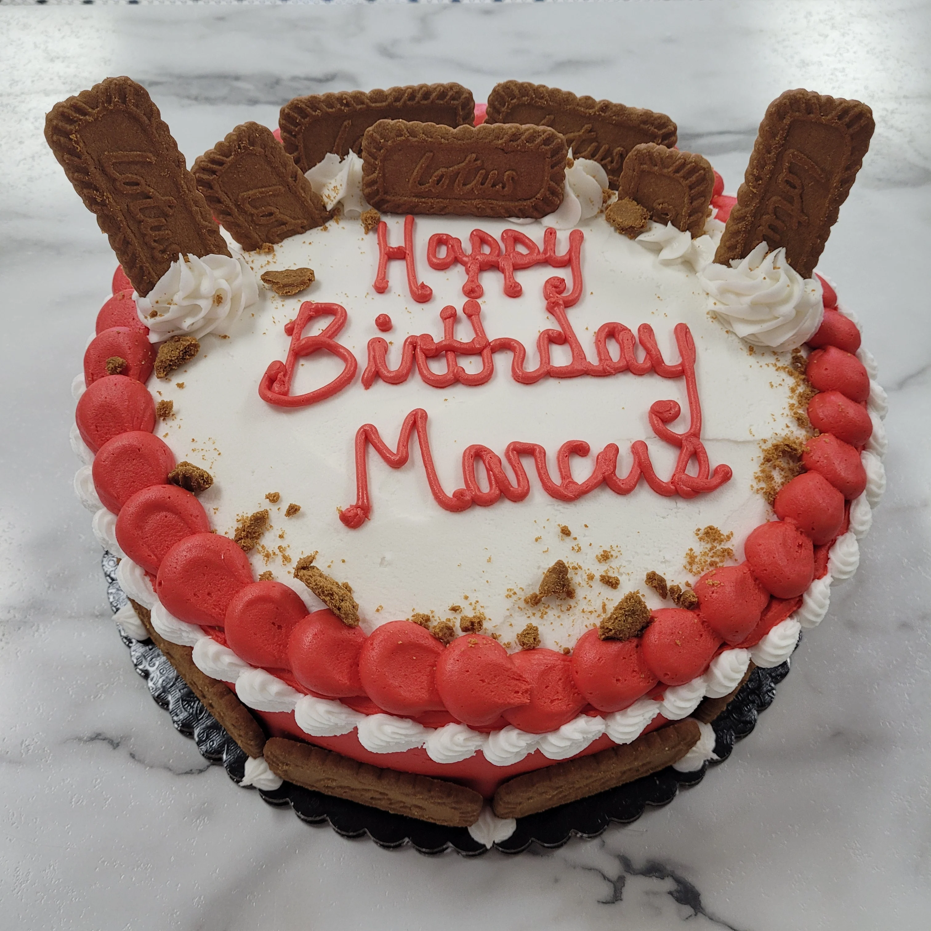Birthday cake decorated with Lotus cookies and red frosting
