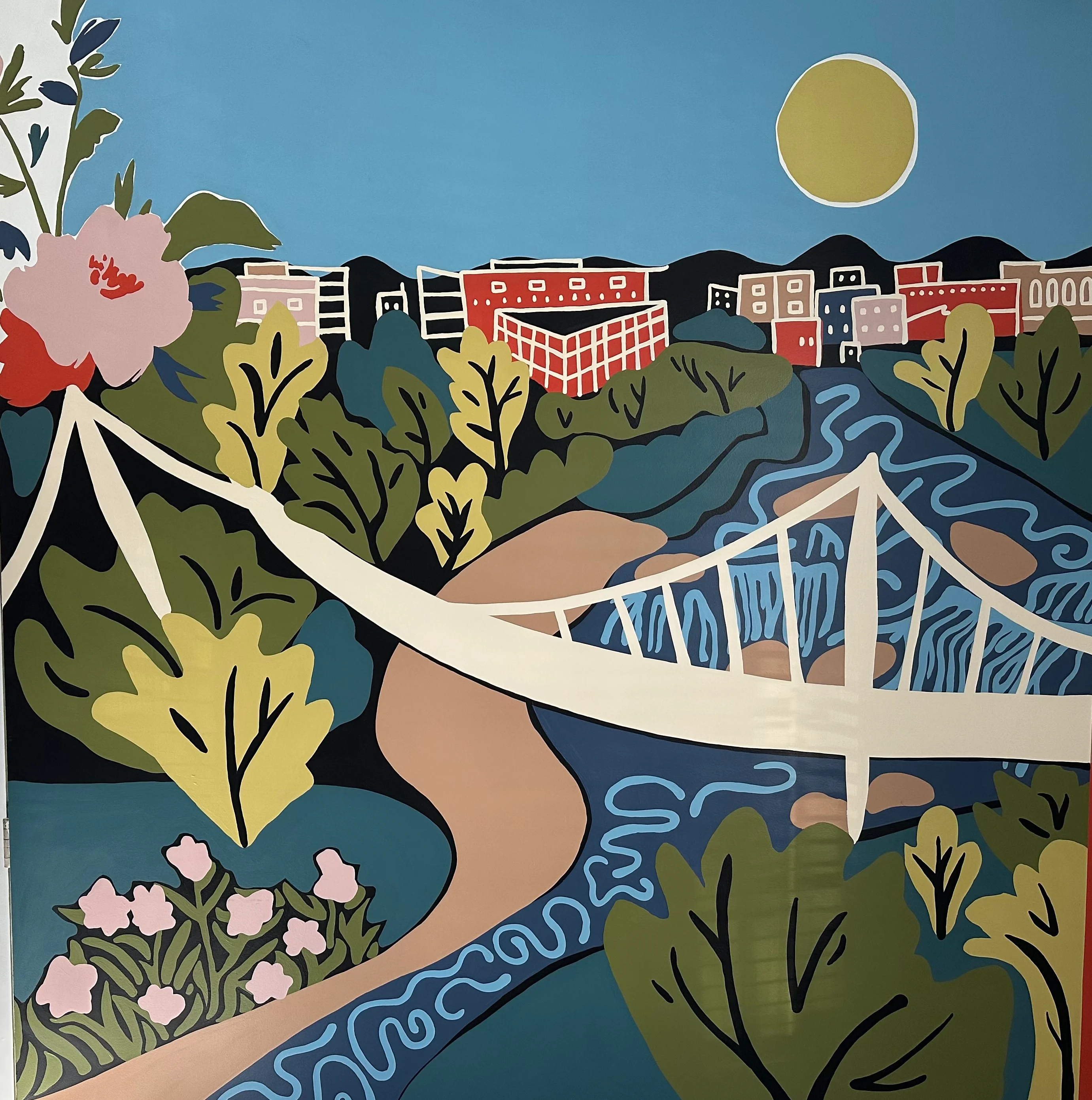 Colorful mural depicting a bridge and landscape with sun and flowers