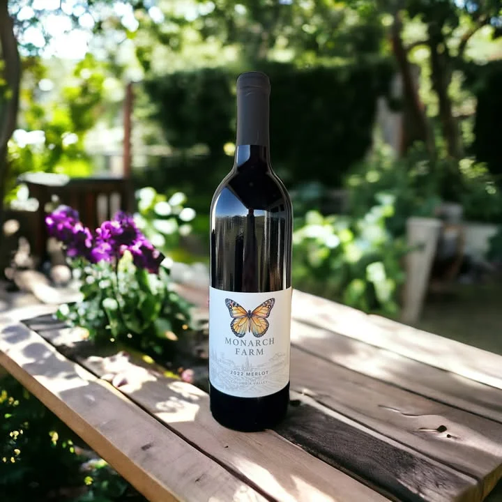 Bottle of 2022 Merlot from Monarch Farm in a garden setting