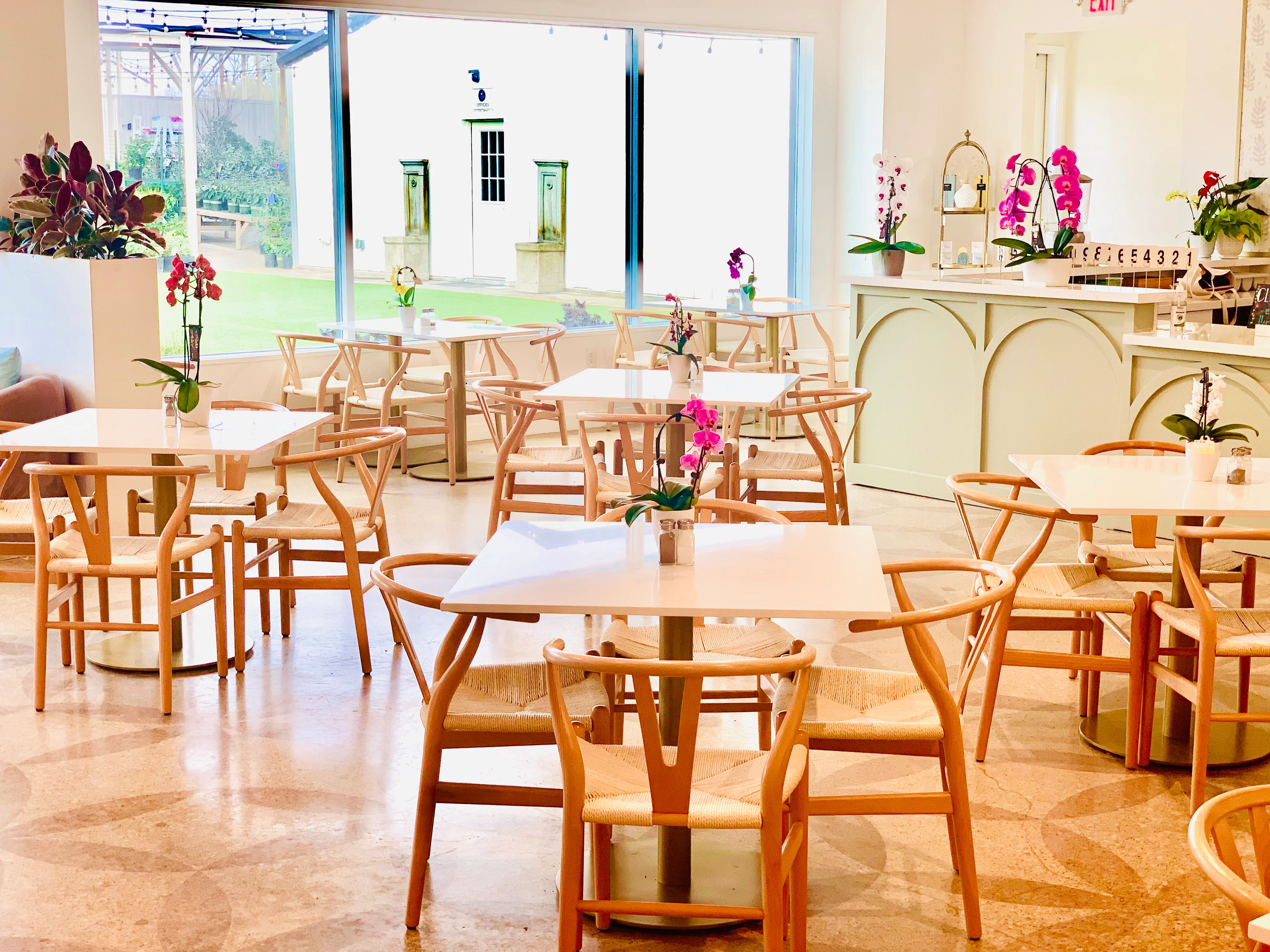 Bright restaurant interior with wooden tables and orchids