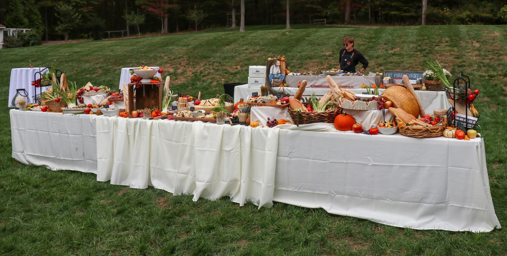 A beautifully arranged outdoor buffet with various foods and decorations.