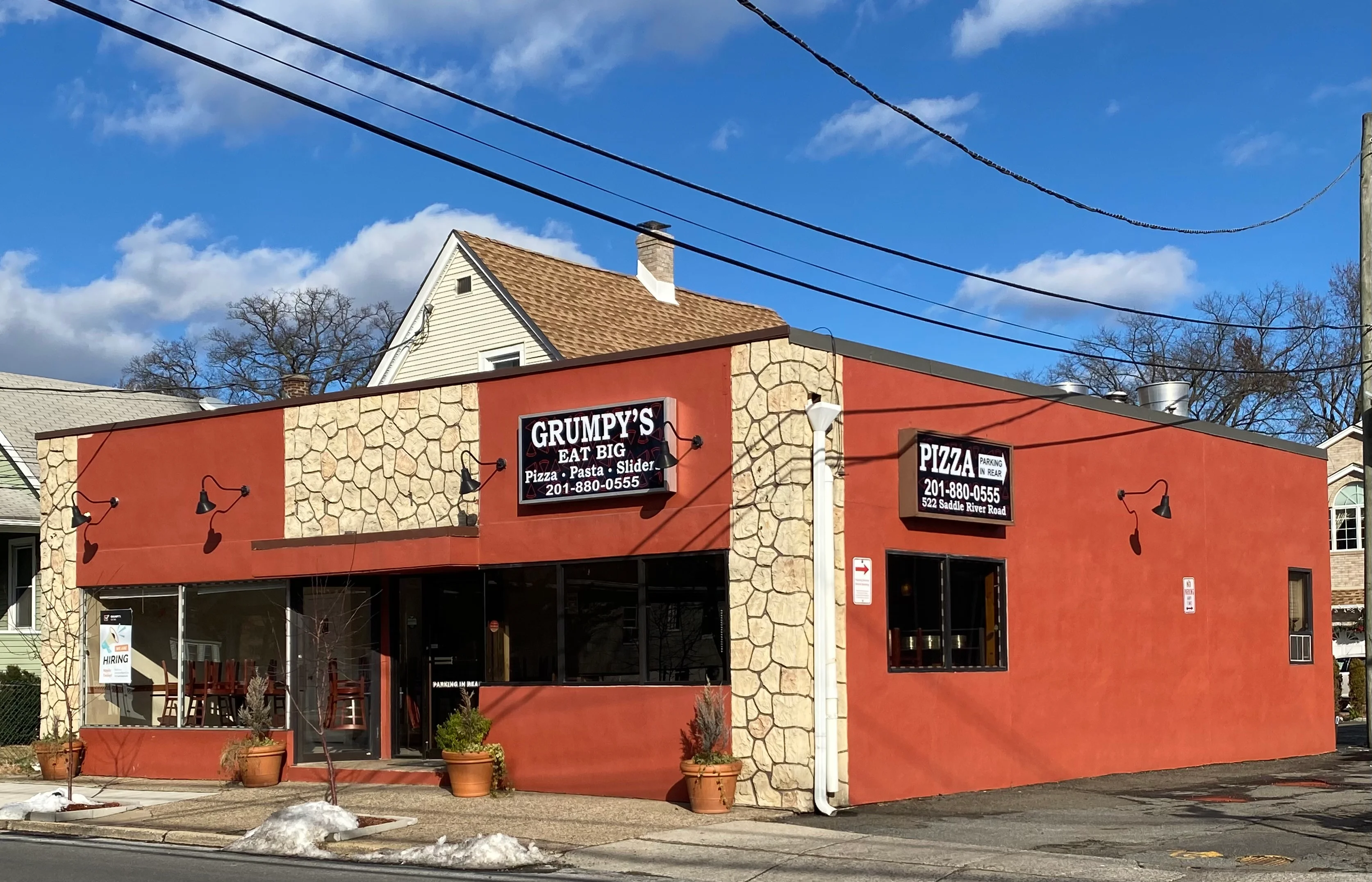 Exterior view of Grumpy's Eat Big restaurant with pizza and pasta offerings