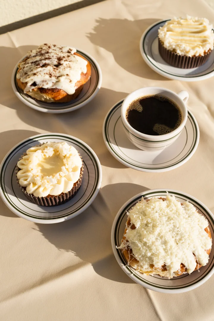 Assorted pastries including cinnamon rolls and cupcakes with coffee