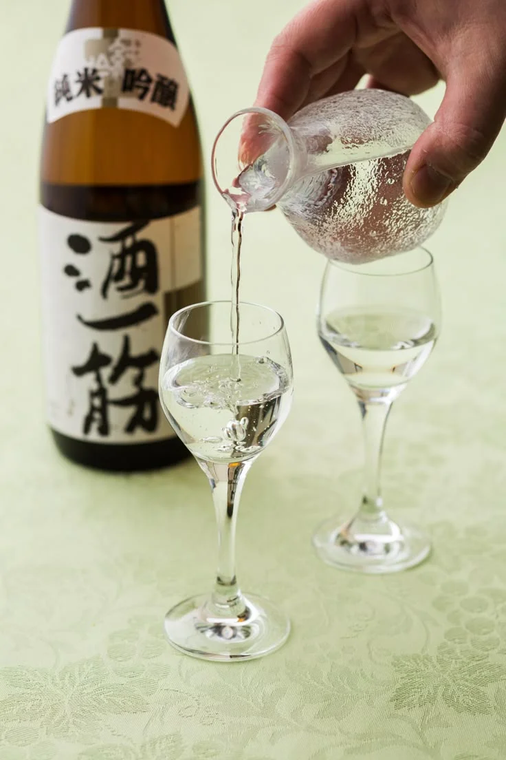 Pouring Japanese sake into glasses
