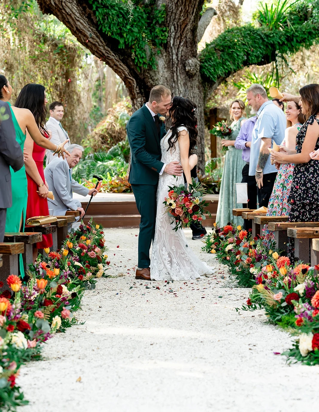 Couple sharing a kiss during a wedding ceremony in a lush garden setting