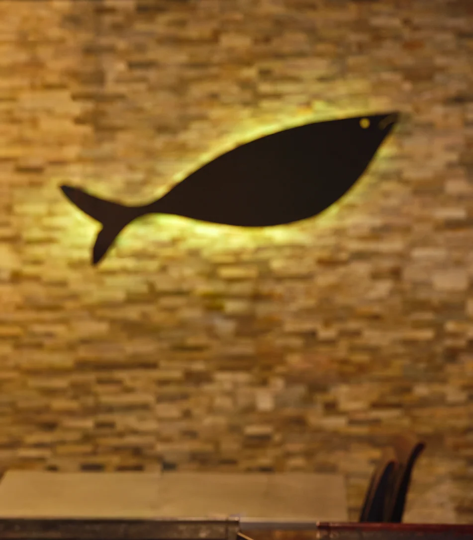 Cozy restaurant interior with stone wall and fish decor