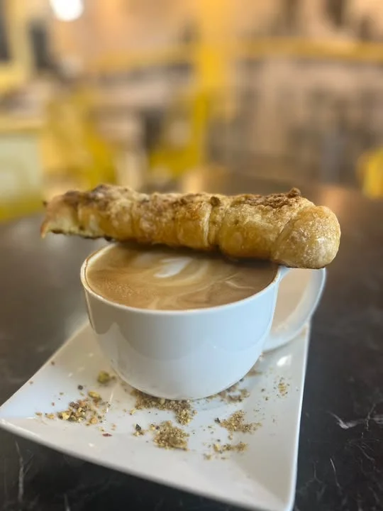 Artisan latte with intricate foam art on a marble table