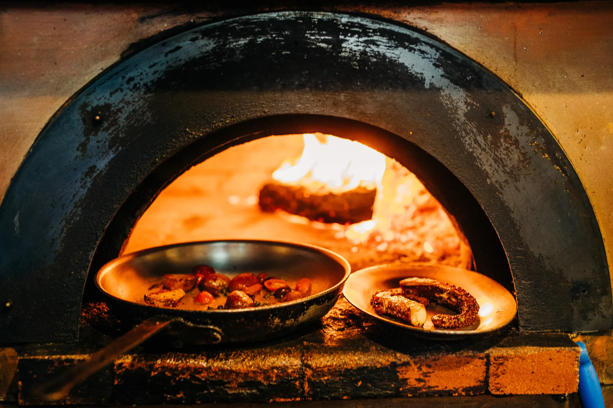 Wood-fired oven with roasted vegetables and fish