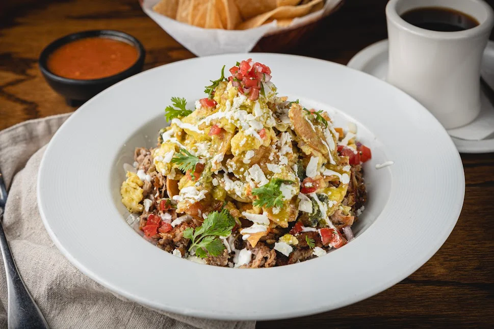 Delicious Mexican chilaquiles topped with eggs and fresh salsa