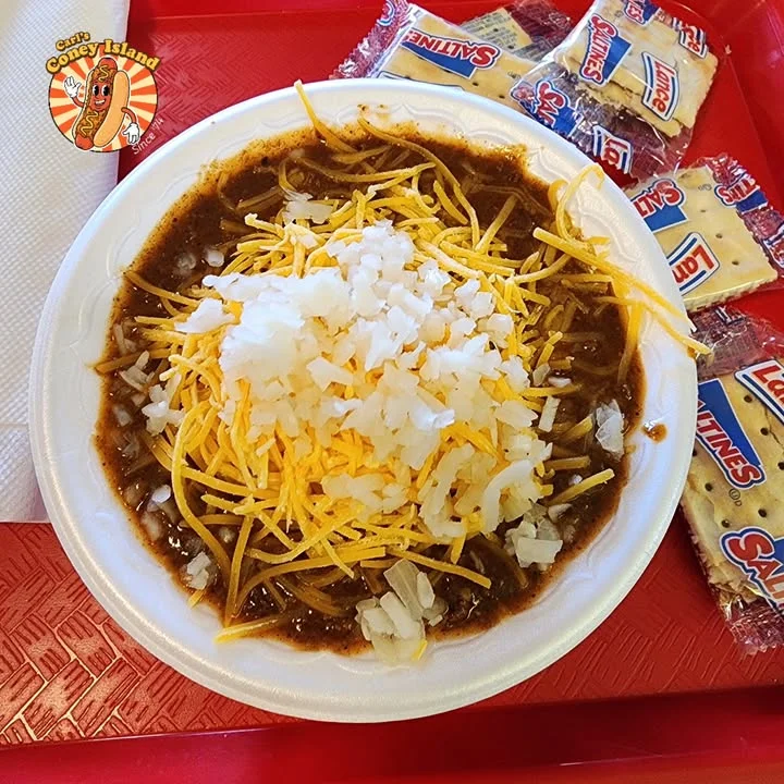 Bowl of chili cheese spaghetti with onions
