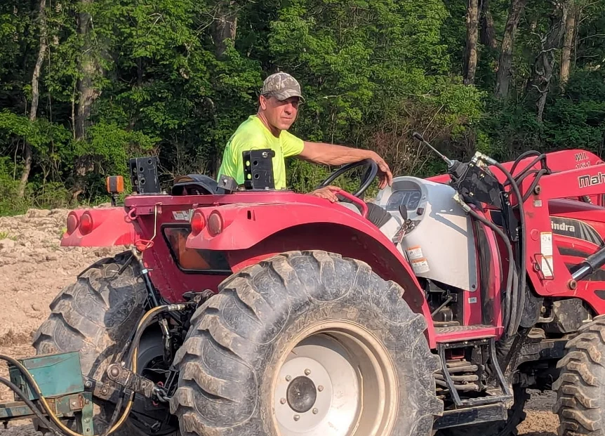 Farmer operating a red tractor in a field
