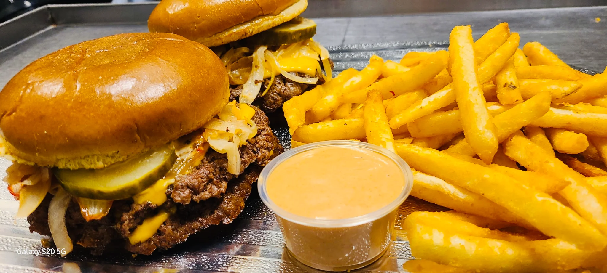 Classic American cheeseburgers with fries and dipping sauce