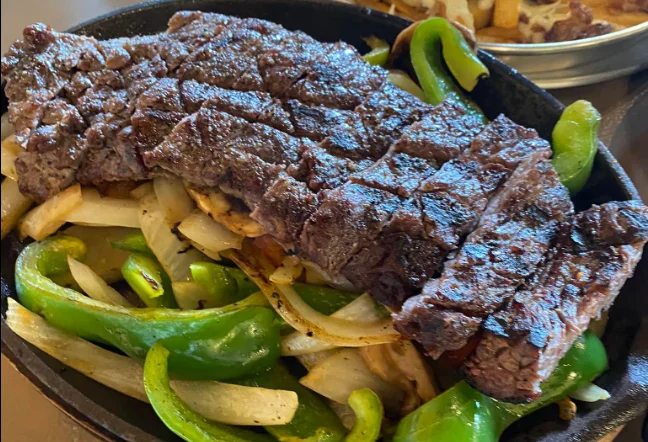 Sizzling fajitas with grilled steak and bell peppers