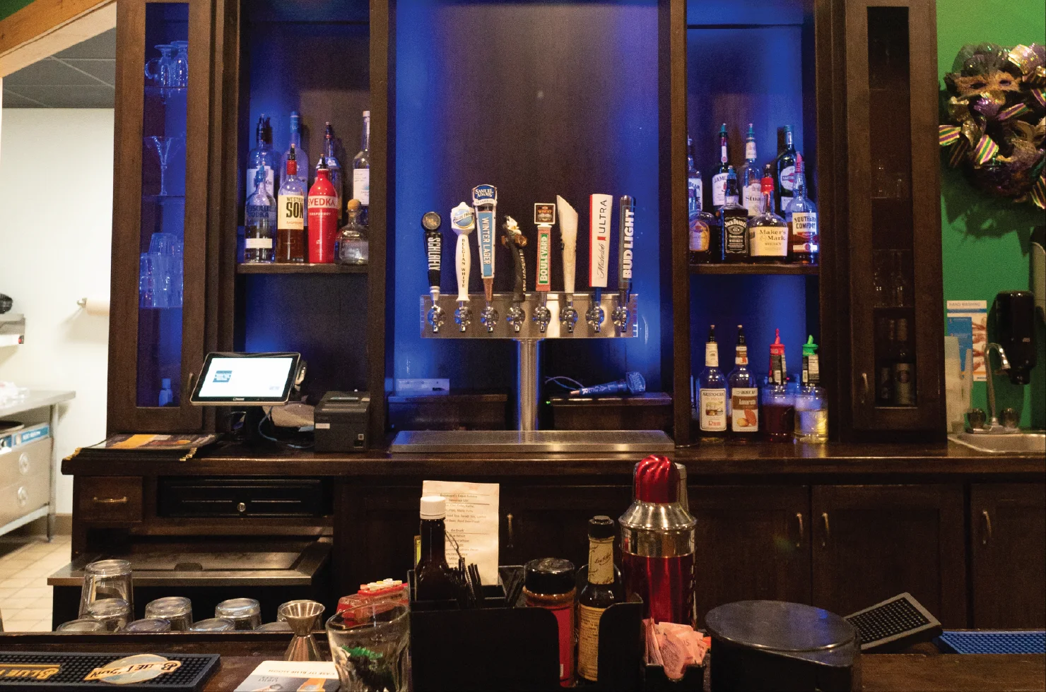 Modern bar counter with various liquor bottles and draft beer taps