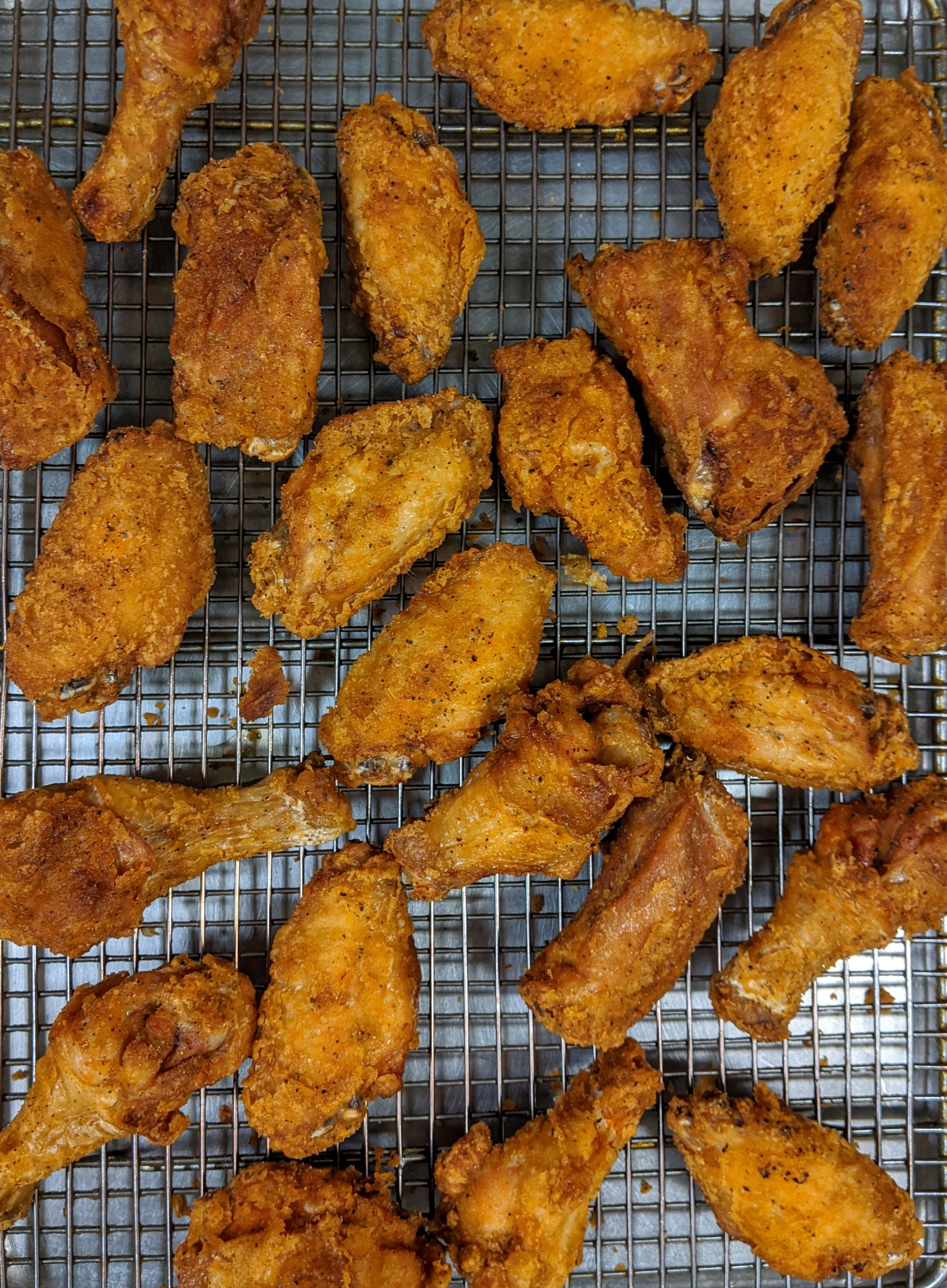 Crispy fried chicken wings on a cooling rack