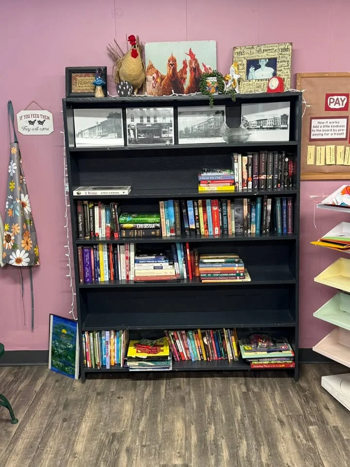 Bookshelf filled with various books and decorative items in a cozy setting
