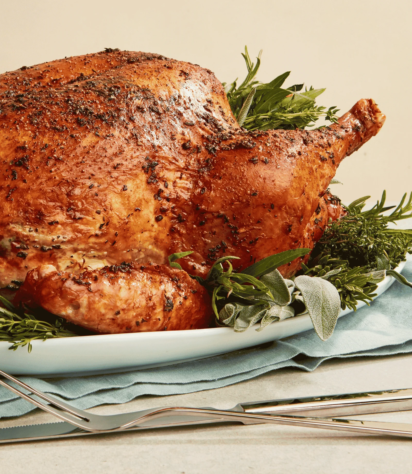 Roasted turkey garnished with herbs on a serving platter.