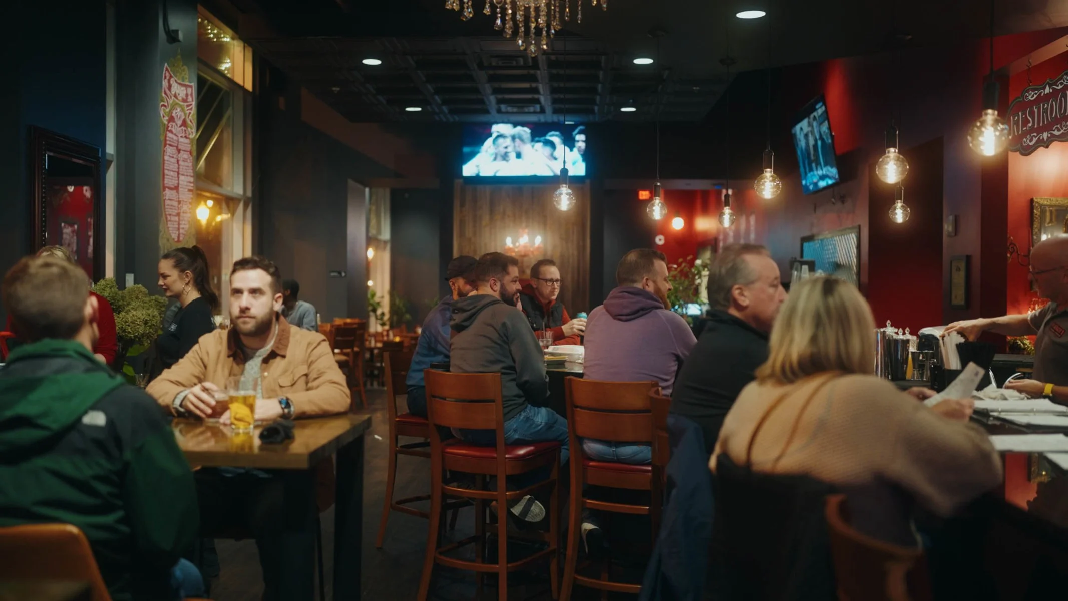 Cozy restaurant interior with patrons enjoying drinks and conversation