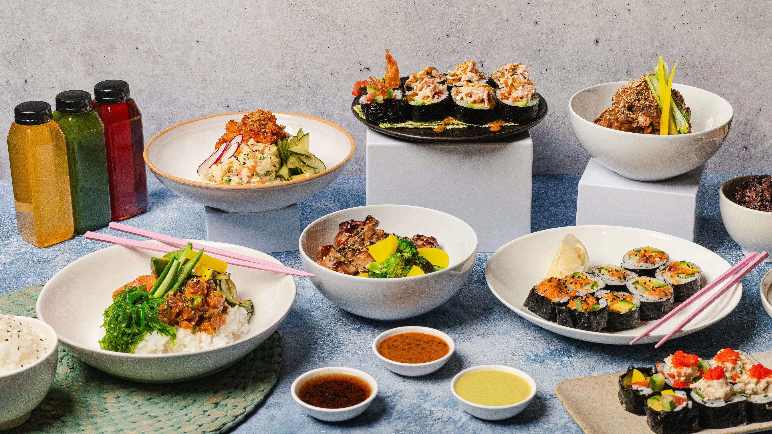 Variety of Asian dishes including sushi, rice bowls, and colorful drinks.