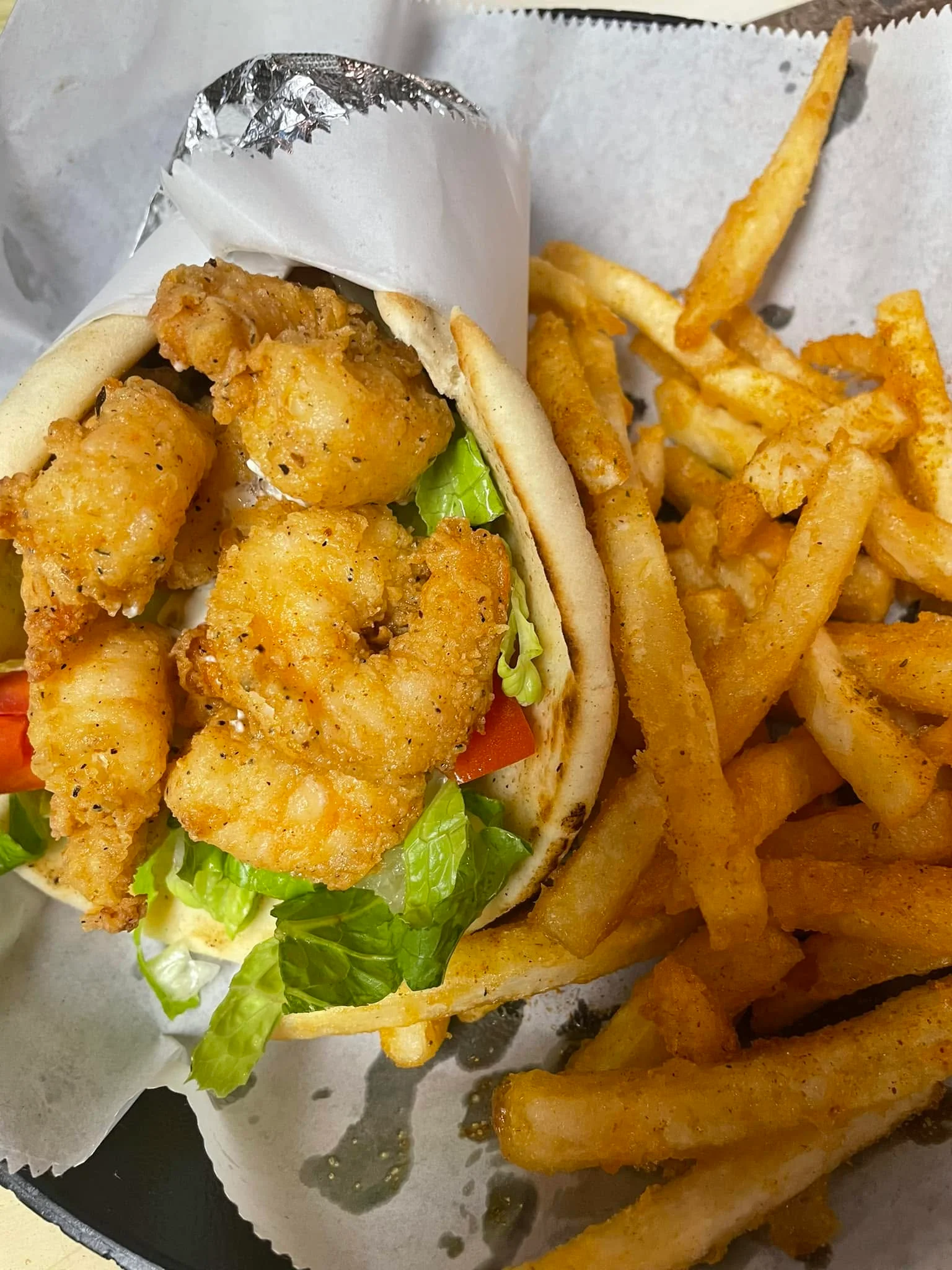Crispy shrimp po' boy sandwich with fries