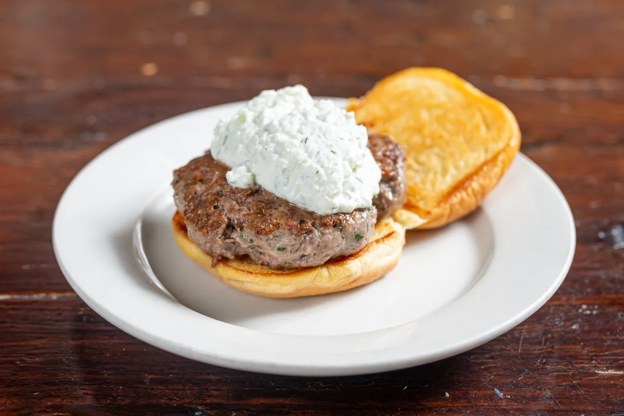 Juicy lamb burger with tzatziki sauce on a toasted bun