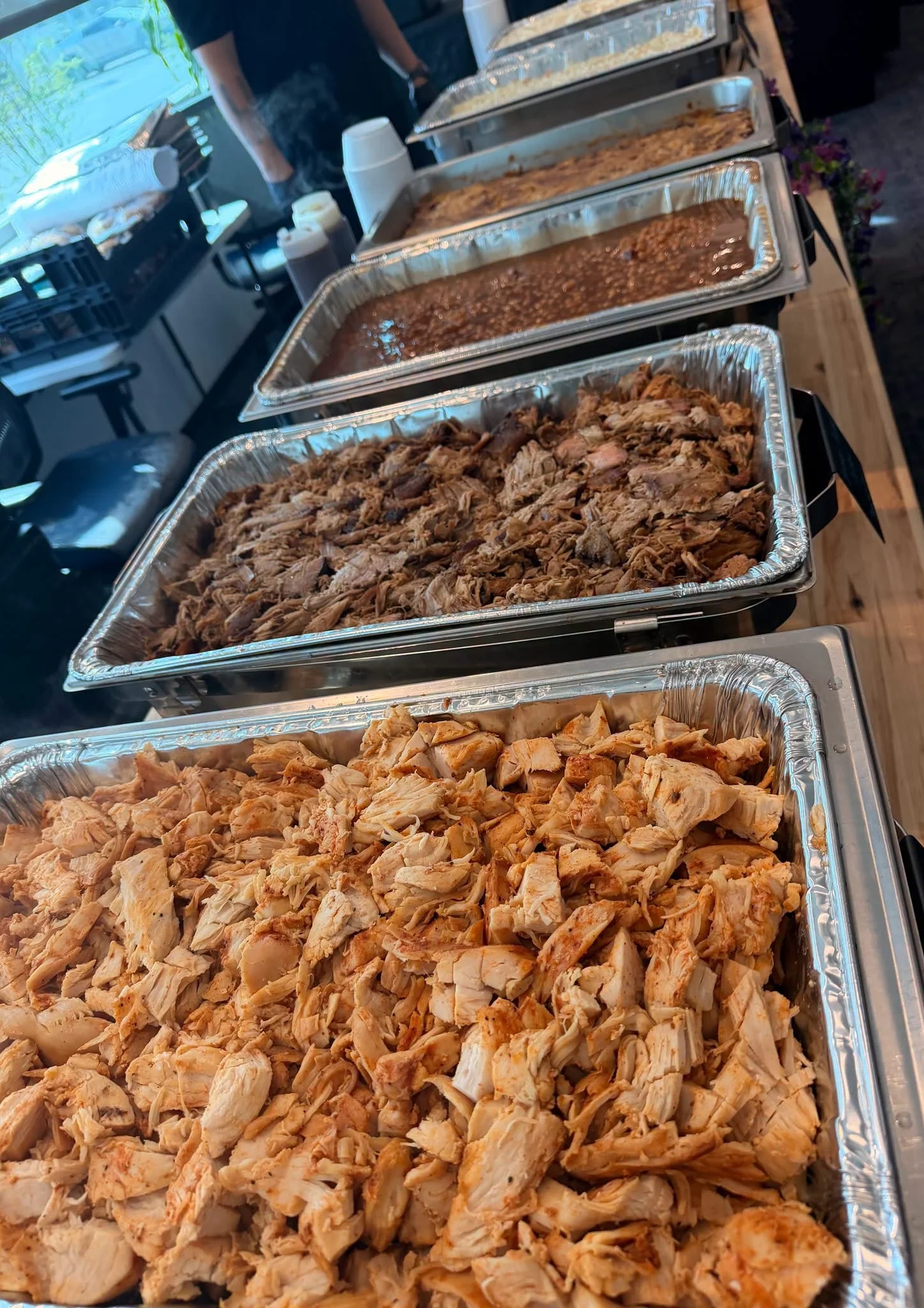 Buffet trays of seasoned shredded chicken and pulled pork
