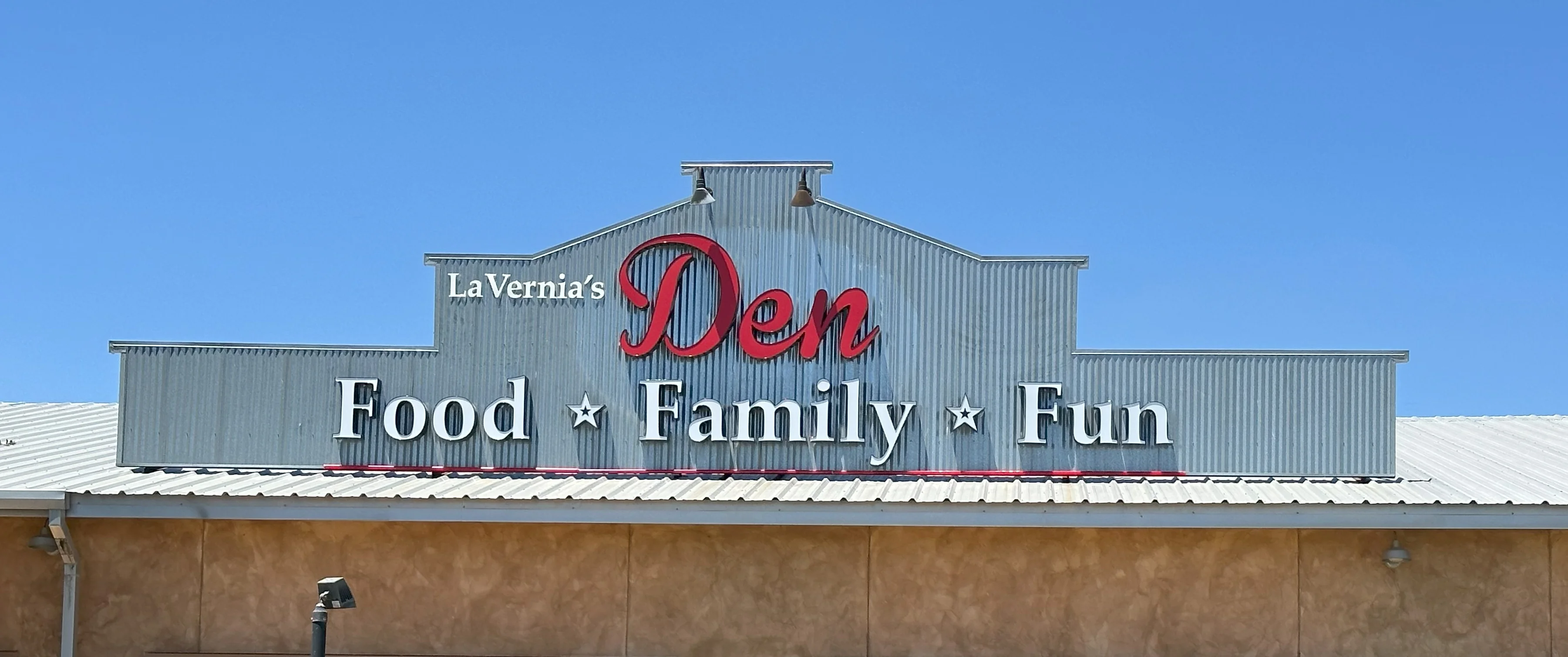 Exterior view of La Vernia's Den restaurant with a bear statue