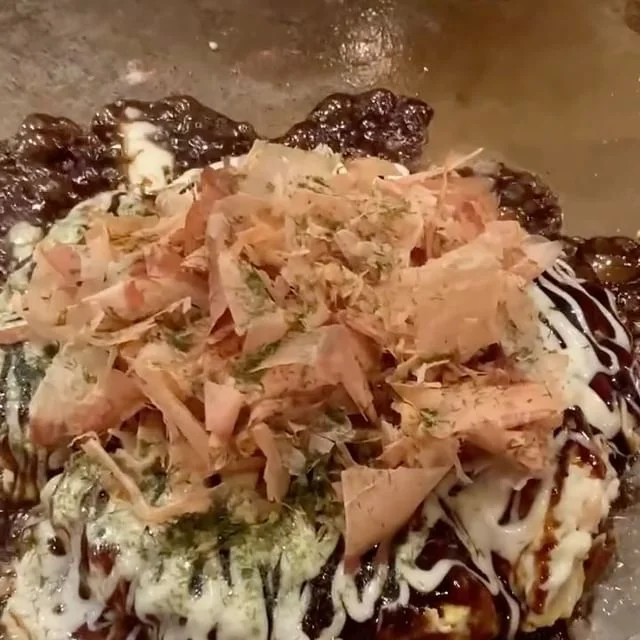 Japanese okonomiyaki topped with bonito flakes