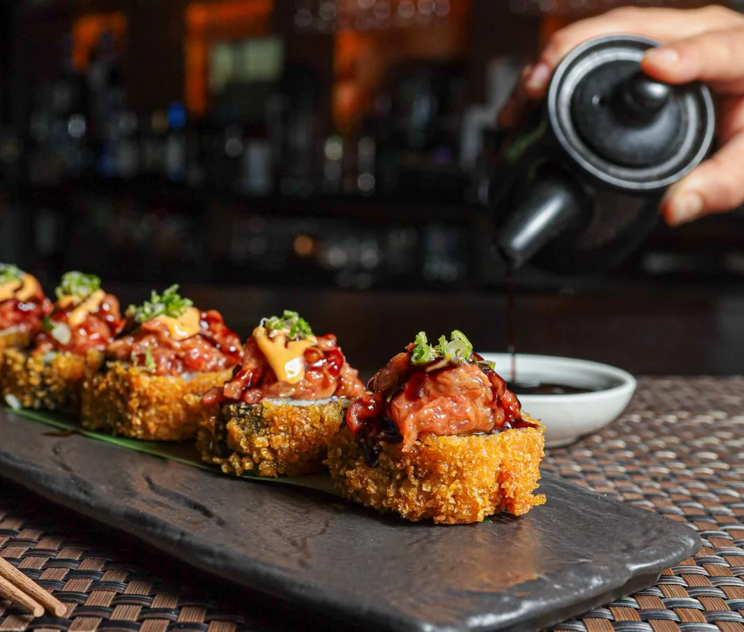Crispy sushi rolls topped with savory sauce