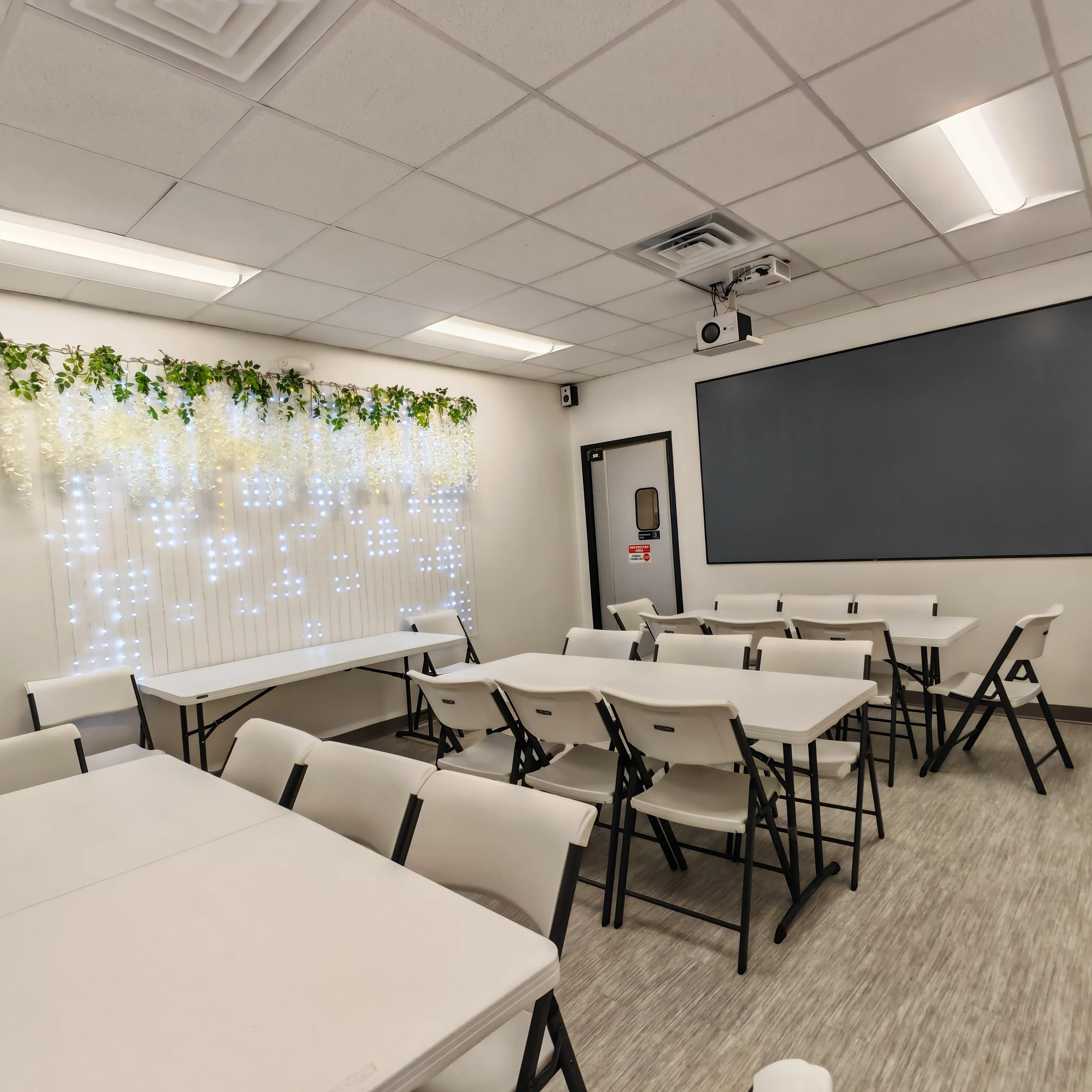 Brightly lit meeting room with folding tables and decorative lights