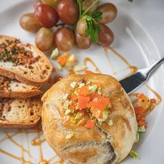 Savory baked pastry with fresh toppings, served with grapes and toast