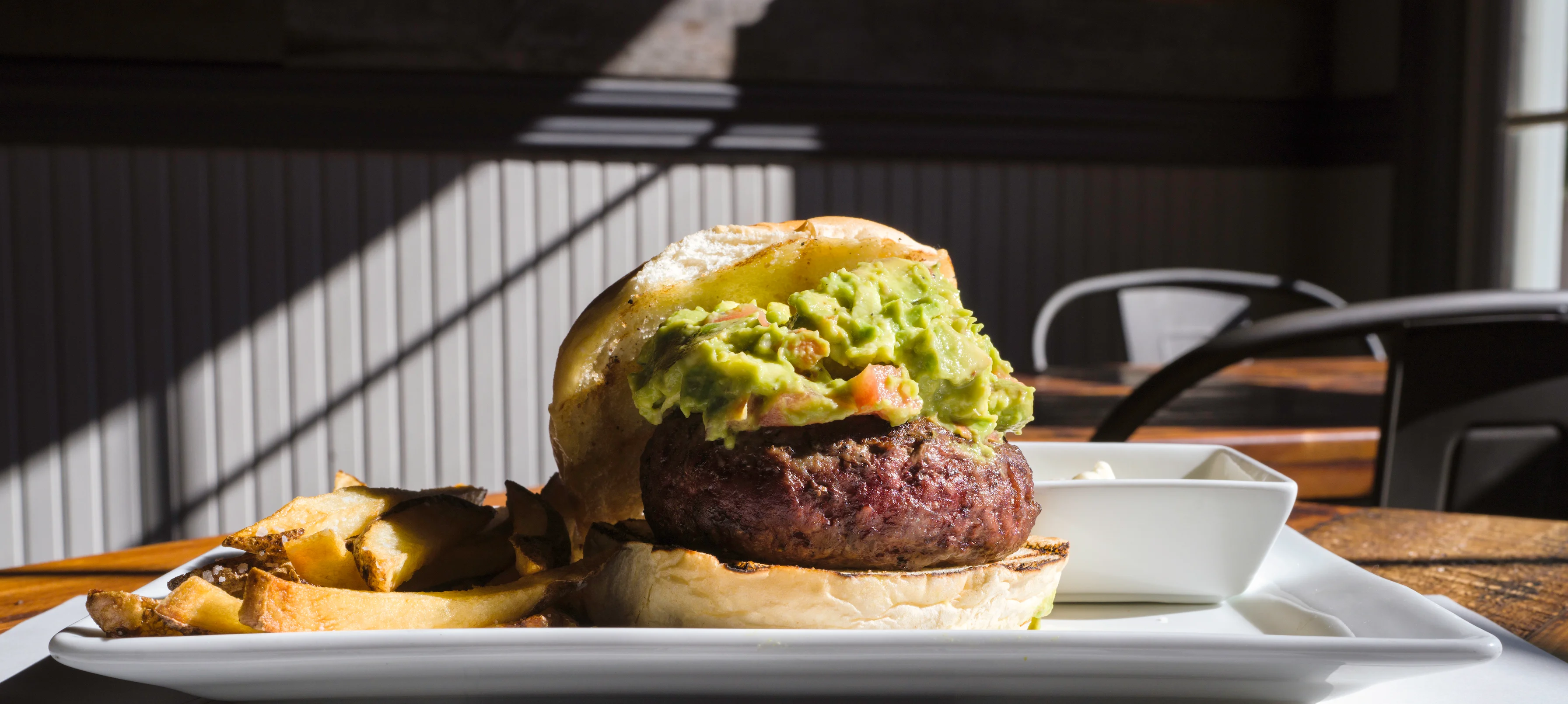 Juicy burger topped with guacamole and served with fries