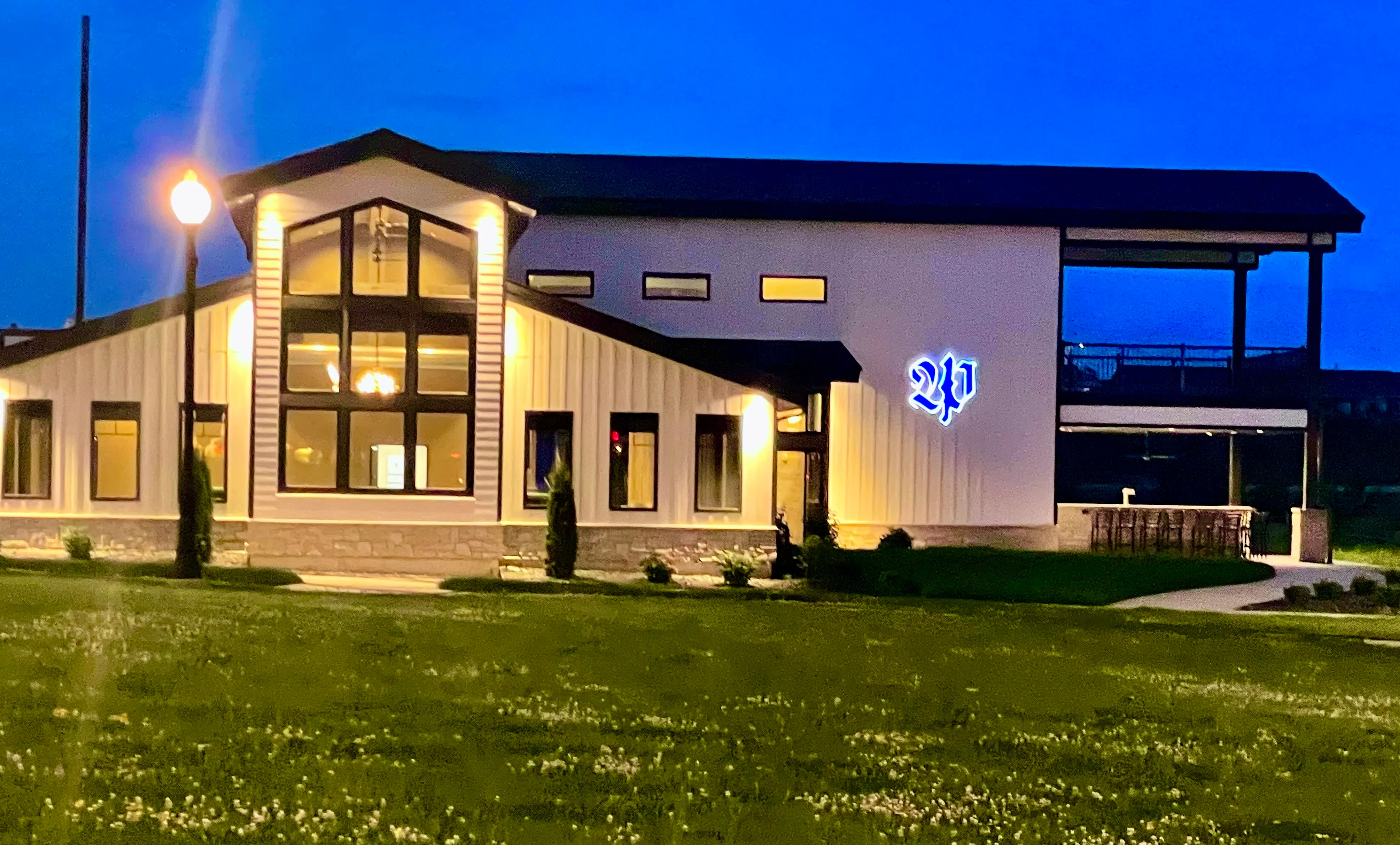 Modern restaurant exterior at dusk with illuminated signage