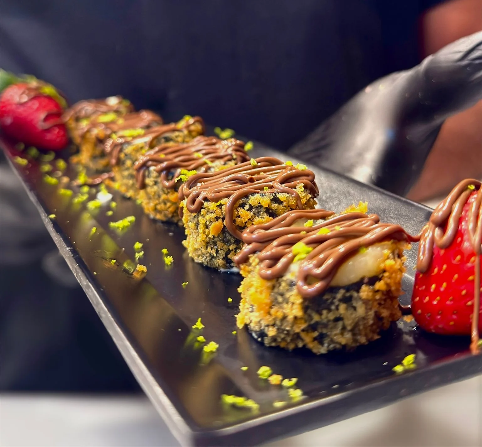 Japanese sushi roll with chocolate drizzle and strawberries
