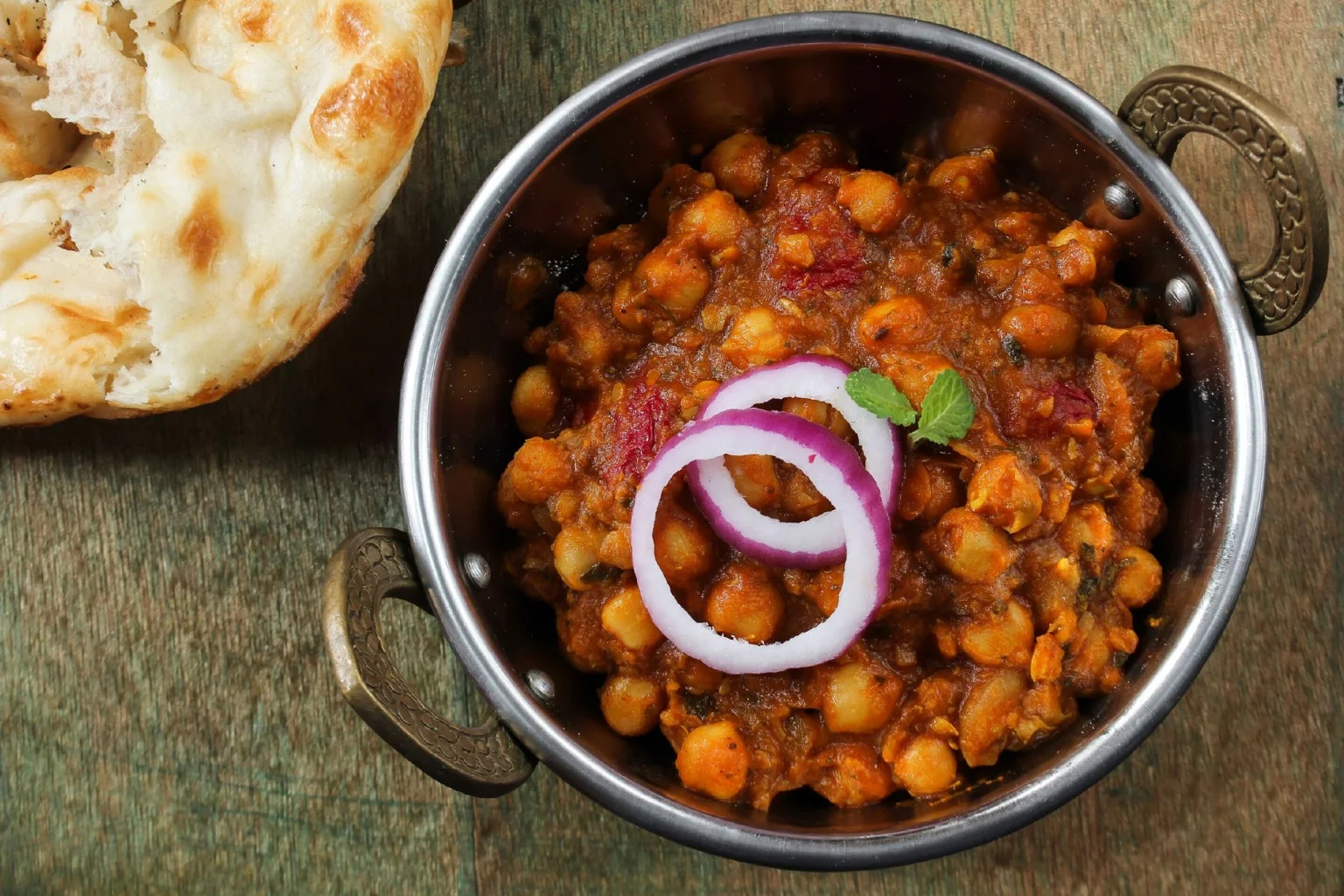 A vibrant plate of Channa Masala garnished with fresh herbs.