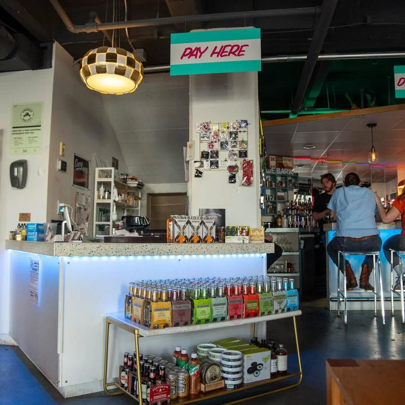 Modern bar counter with a payment area and colorful beverage display