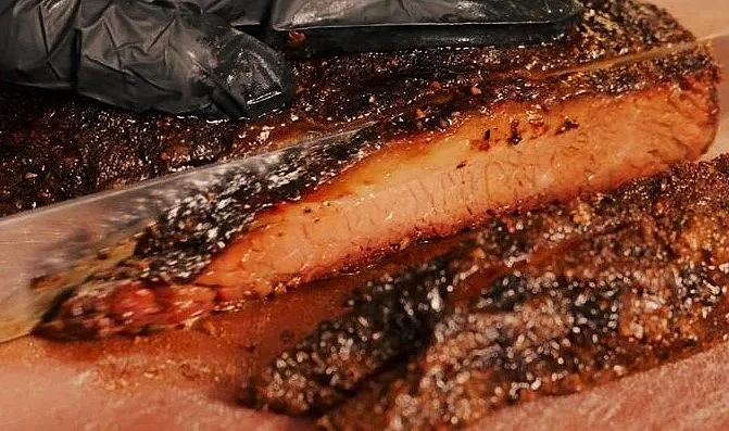 Deliciously smoked brisket served on a wooden platter.