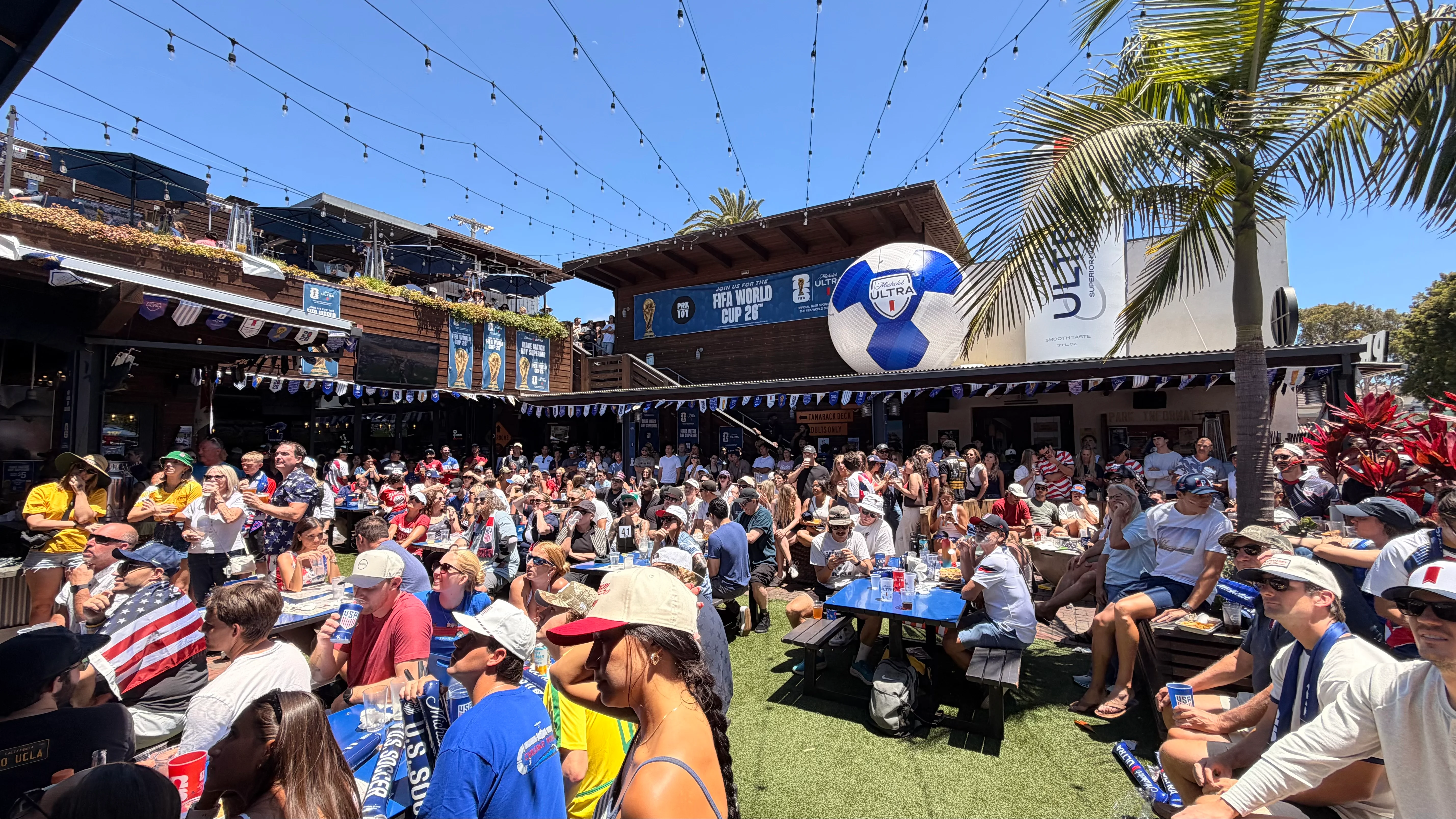 Crowd enjoying a lively outdoor sports event at a restaurant