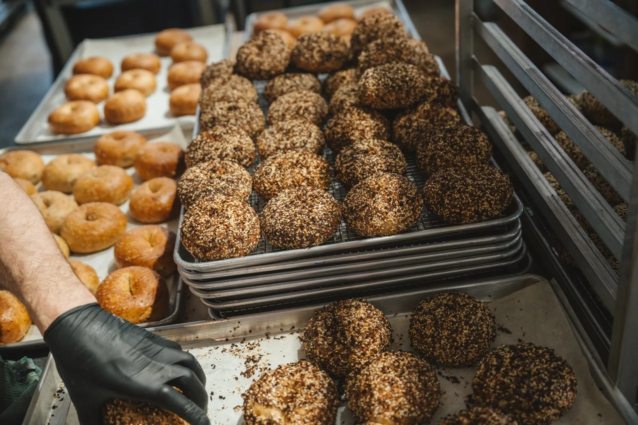 Freshly baked sesame bagels cooling on racks