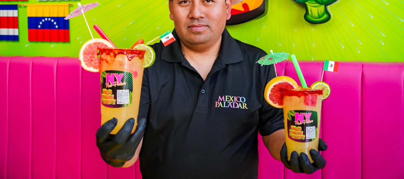 Bartender showcasing vibrant Mexican cocktails with garnishes