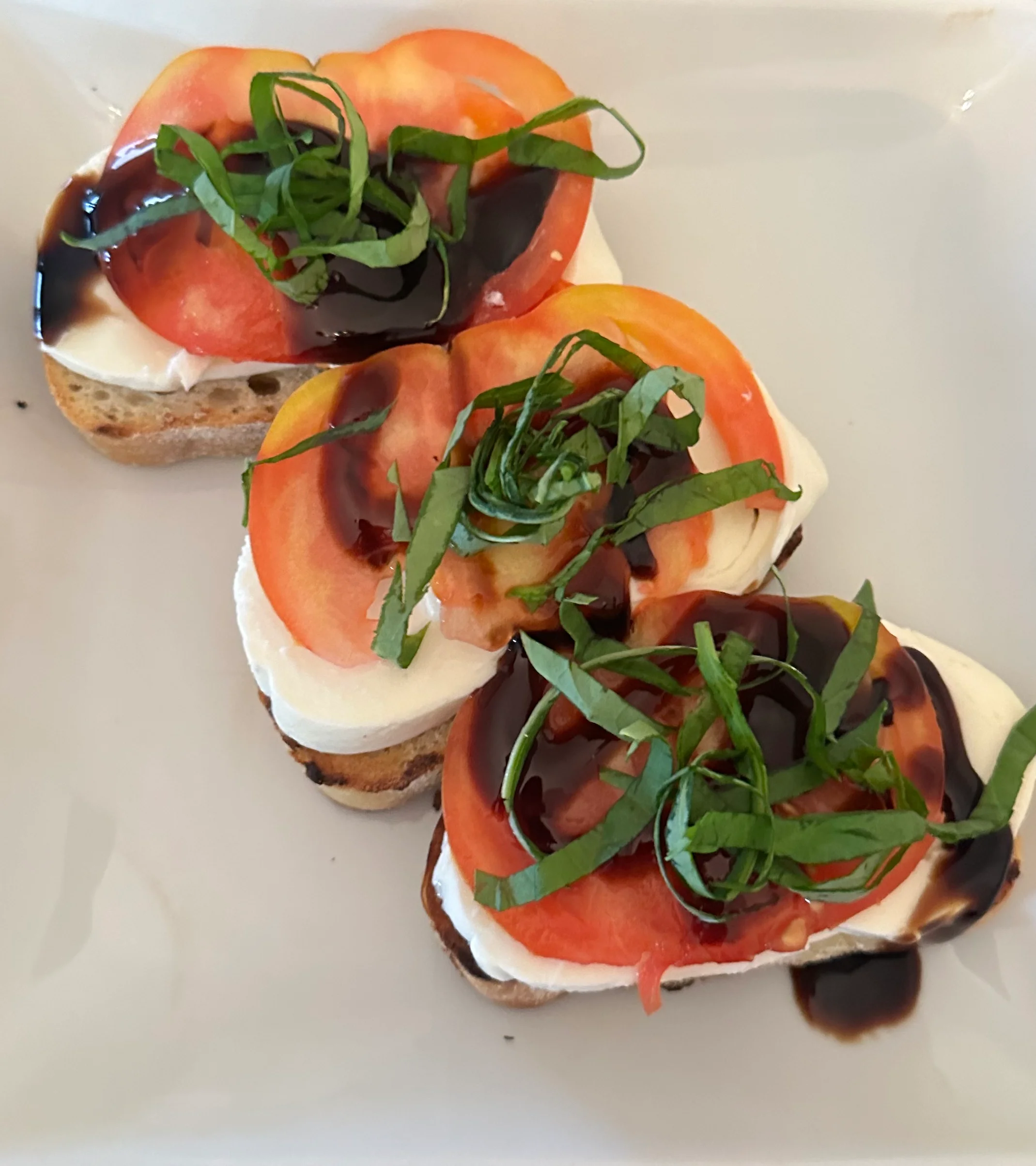 Caprese bruschetta with fresh basil and balsamic glaze
