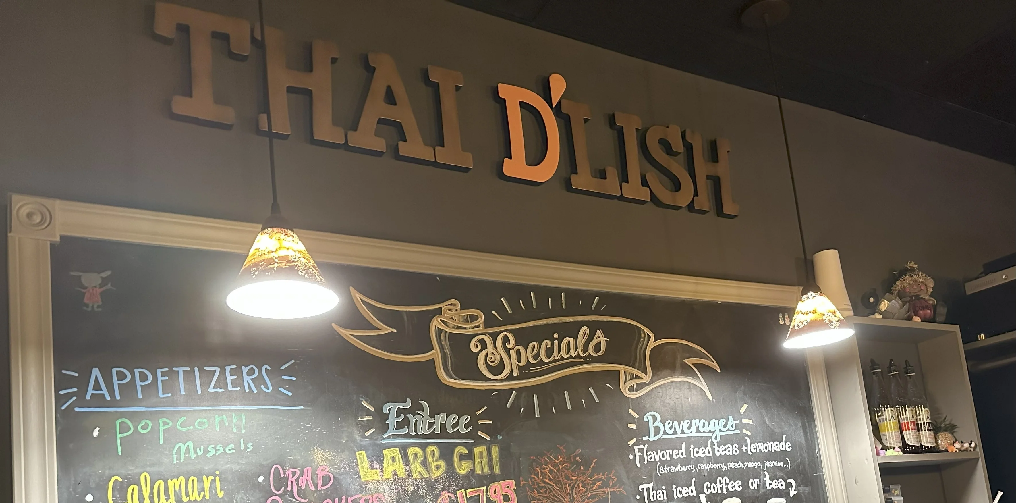 Chalkboard menu at Thai restaurant featuring Larb Gai and appetizers