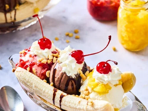 A banana split with three scoops of ice cream, whipped cream, and cherries.