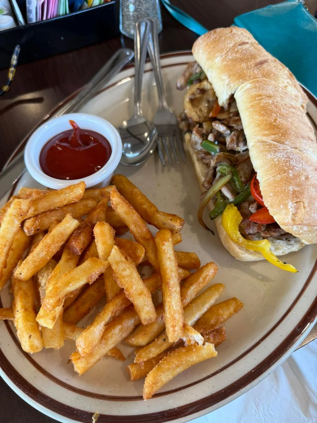 Philly cheesesteak sandwich with fries